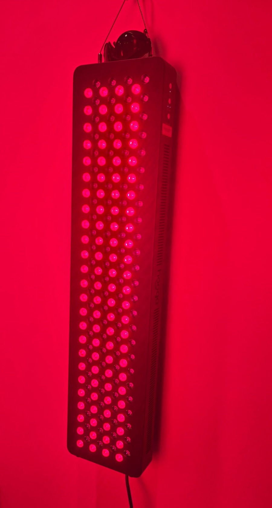 Akron Cryo's actual vertical red light therapy device operating with its LEDs illuminated