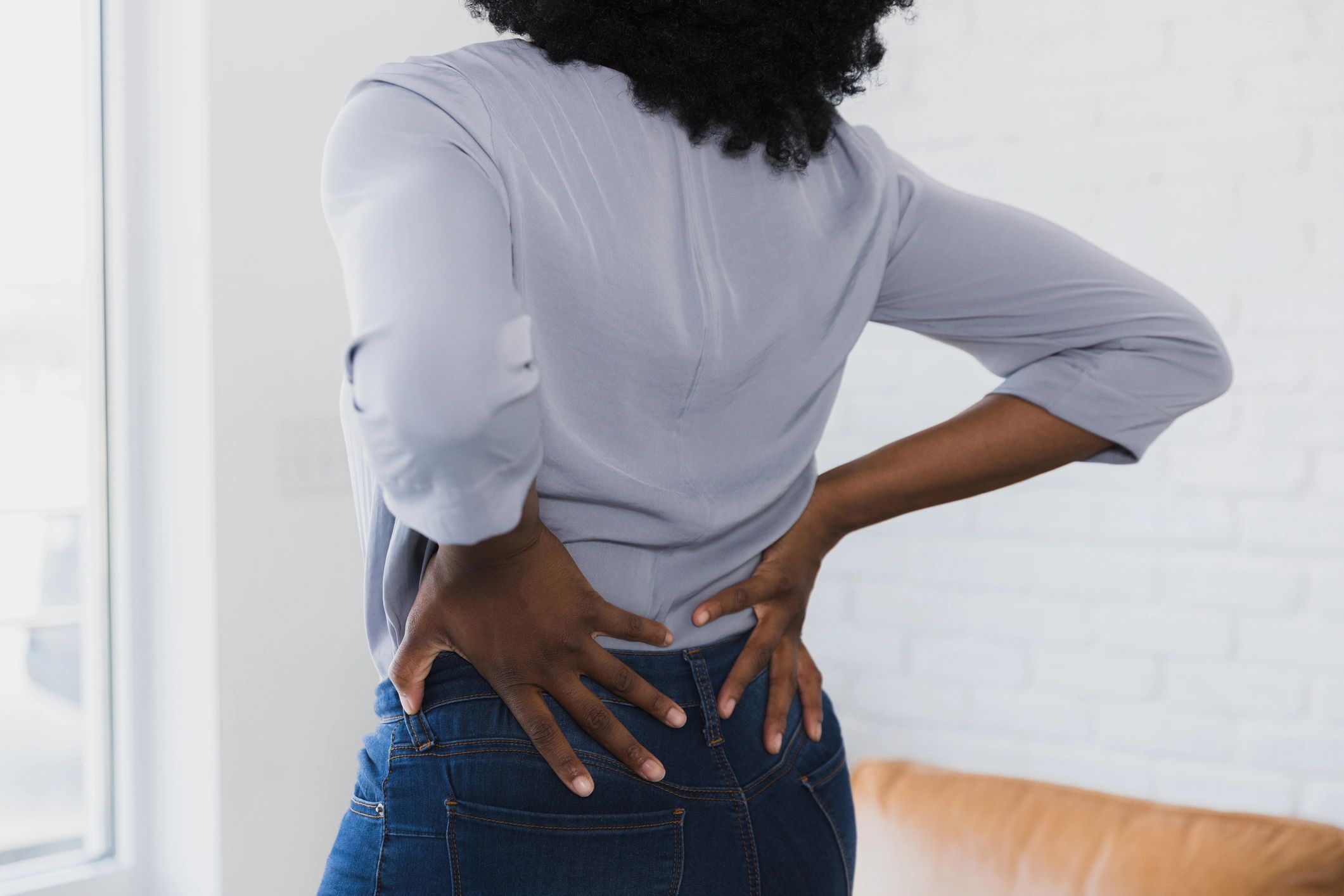 Person holding lower back to indicate pain relief goals